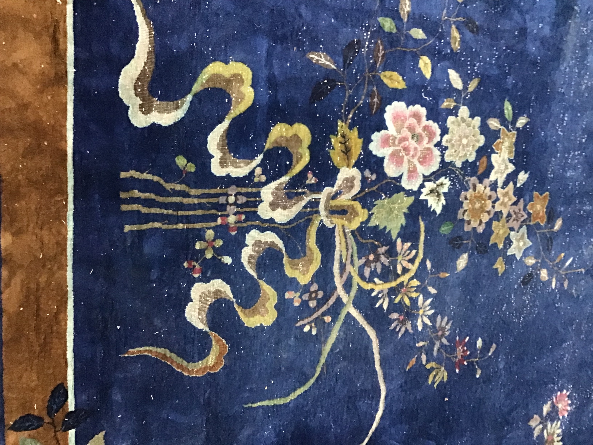 An early 20th century Chinese blue ground carpet woven with butterflies and flowering branches 450cm x 370cm